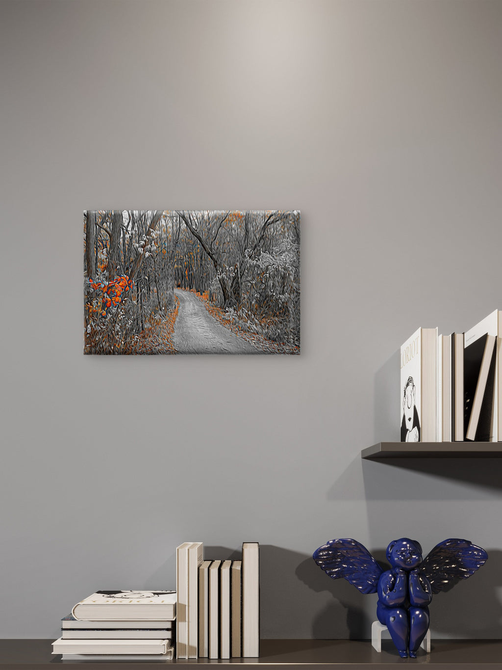 A rectangular wall art print showing a snowy forest path with orange leaves, displayed on a gray wall above a shelf with books and a blue decorative object.